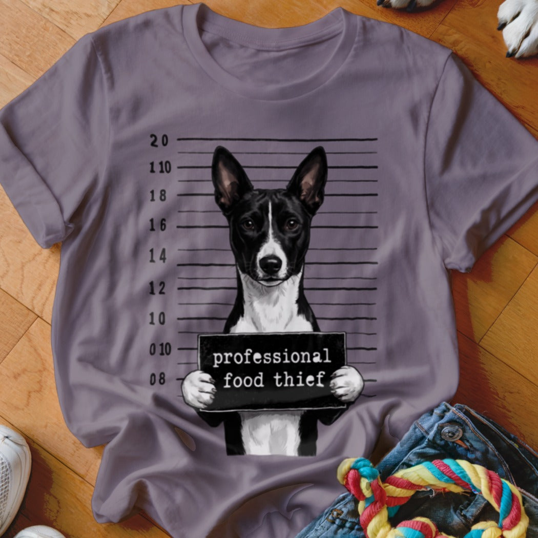 Basenji dog mugshot with "professional food thief" text on a grey t-shirt.
