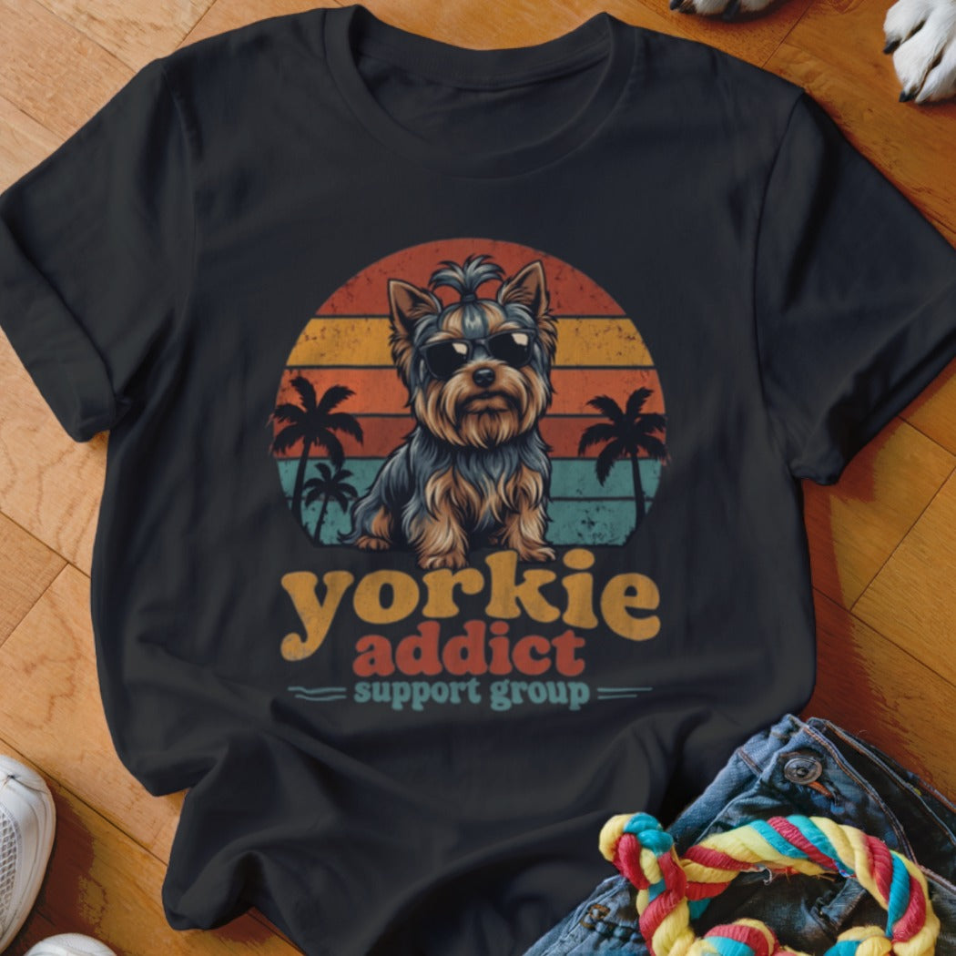 A black t-shirt features a vintage sunset graphic with a Yorkshire terrier wearing sunglasses and palm trees.