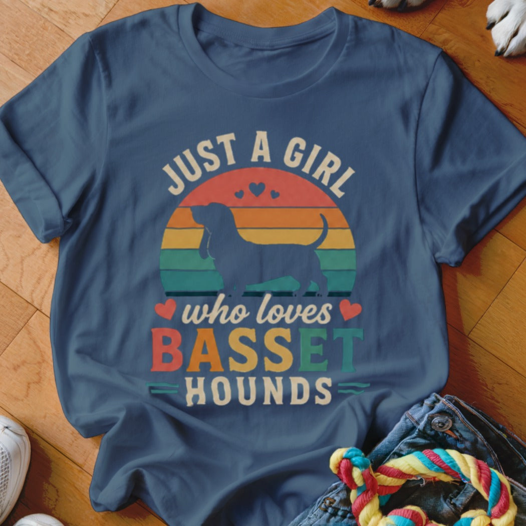 Blue t-shirt with a silhouette of a Basset Hound, colorful sunset graphic, and text "Just a Girl who loves Basset Hounds".