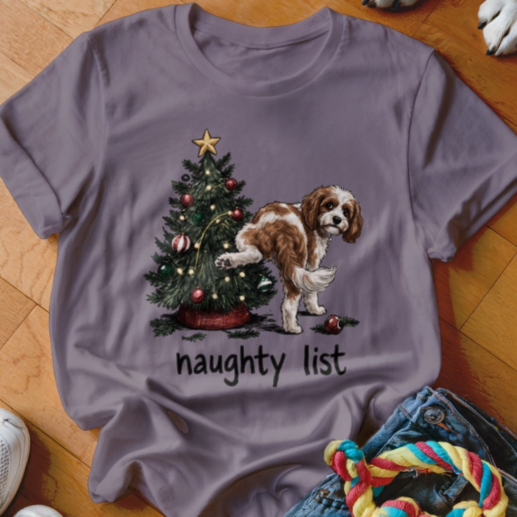Brown and white dog with paw raised near Christmas tree, text reads "naughty list."