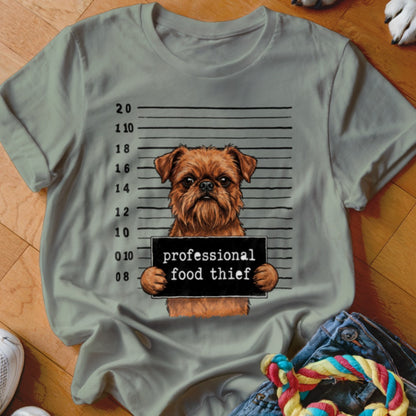 Brown dog in mugshot holding sign "professional food thief"
