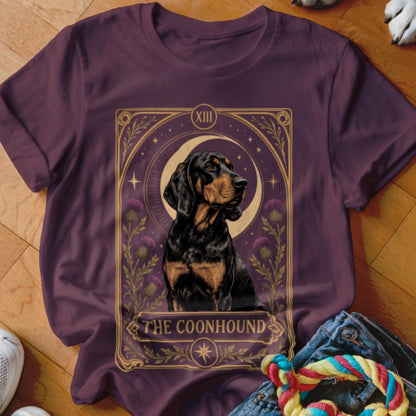 Plum t-shirt featuring a tarot-style graphic of a Black and Tan Coonhound with the text The Coonhound.