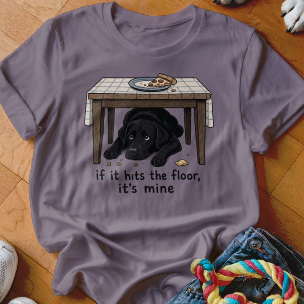 Black lab hiding under table with pizza, "if it hits the floor, it's mine."