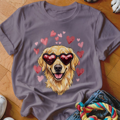 A grey t-shirt featuring a graphic of a golden retriever wearing heart-shaped sunglasses surrounded by floating pink hearts.