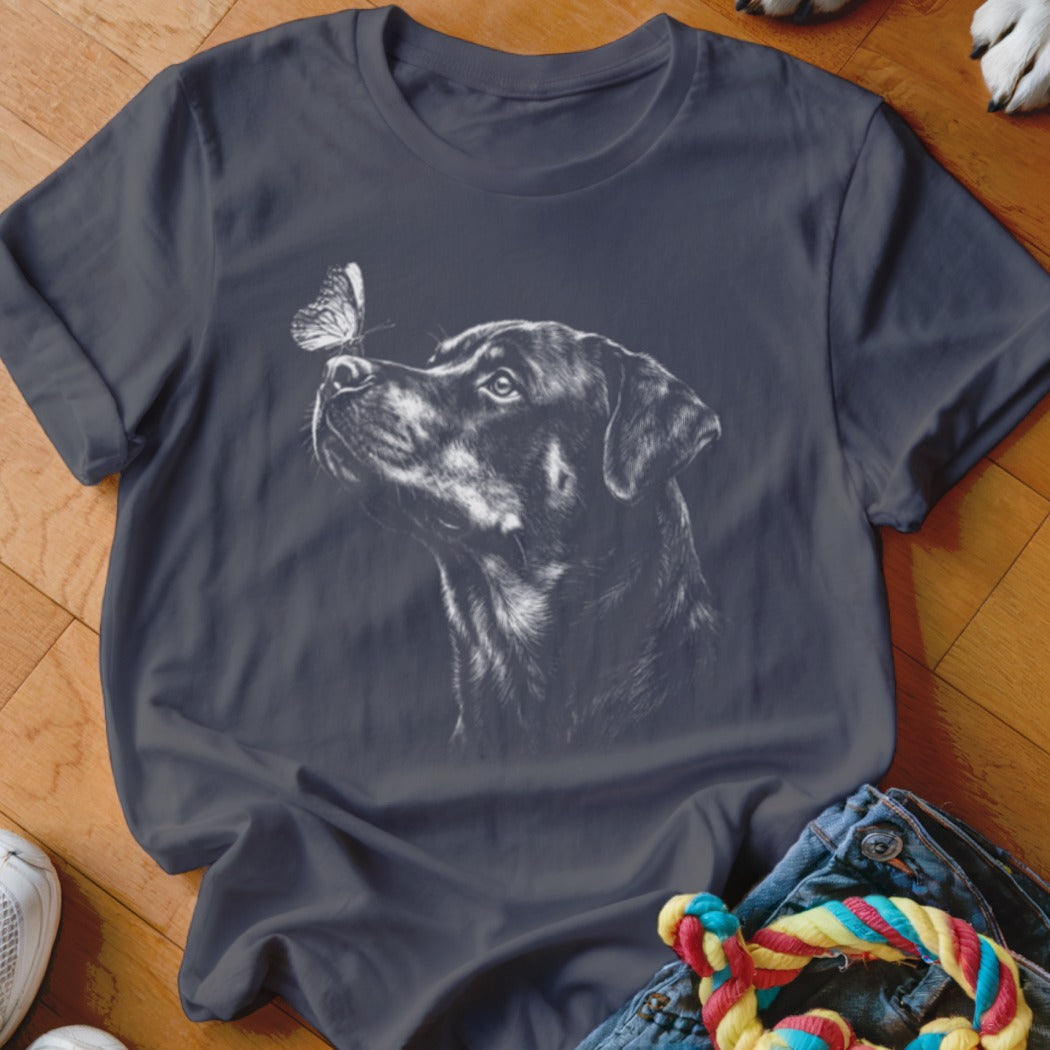 Charcoal grey t-shirt featuring a white line drawing of a dog looking at a butterfly on its nose.