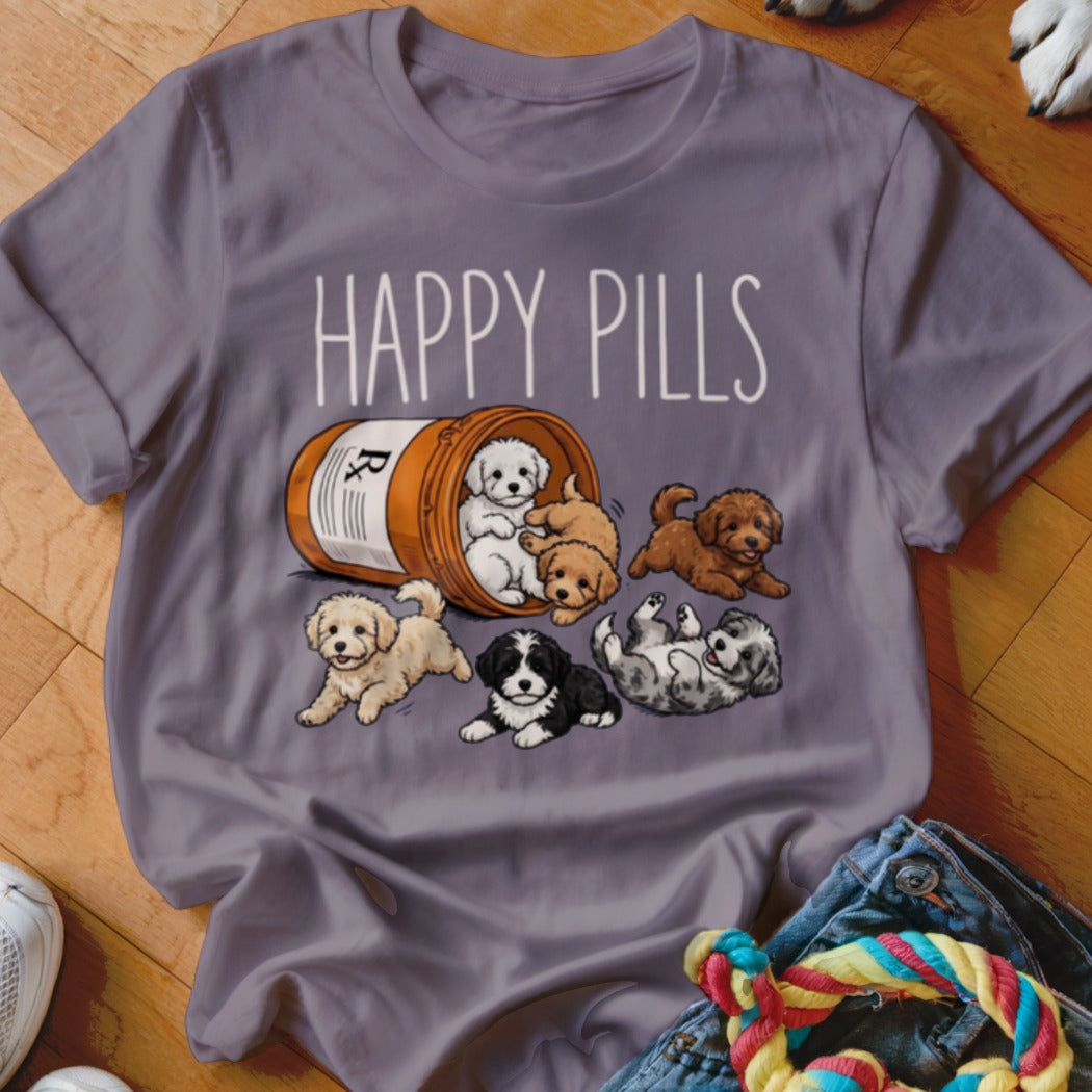 Gray t-shirt with "HAPPY PILLS" text and illustration of puppies spilling from a prescription bottle.