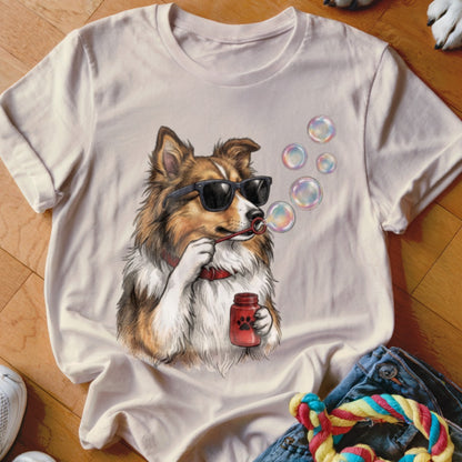 Light-colored t-shirt featuring an illustrated dog wearing sunglasses and blowing soap bubbles.