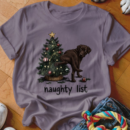 Brown Labrador next to a Christmas tree with "naughty list" text.