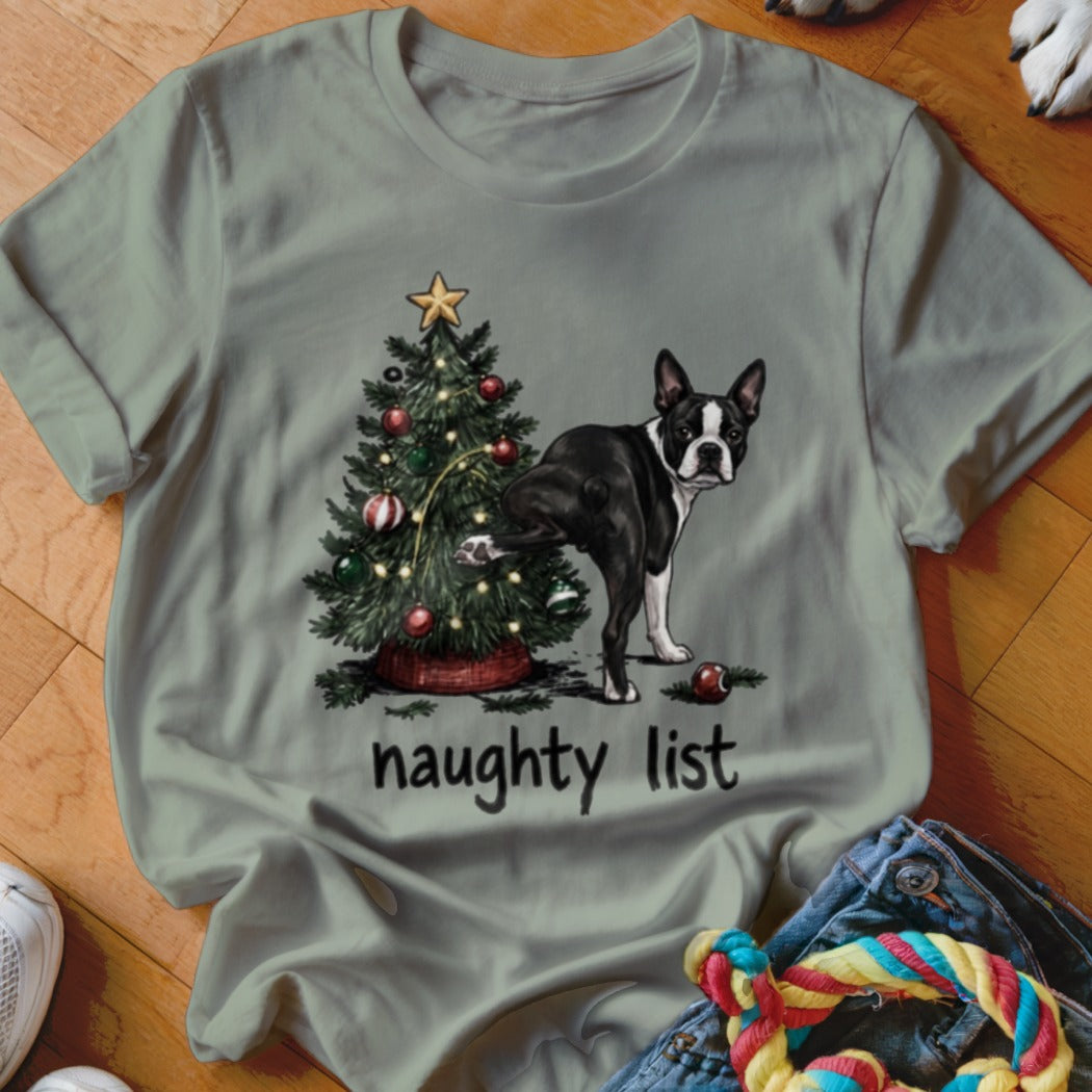 Boston Terrier lifts leg on Christmas tree with text "naughty list" below.