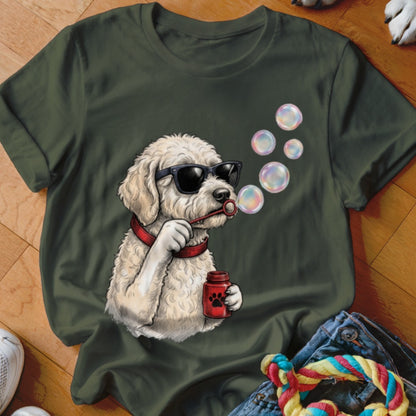 An olive green crewneck t-shirt featuring a graphic of a curly white dog wearing sunglasses and blowing bubbles.