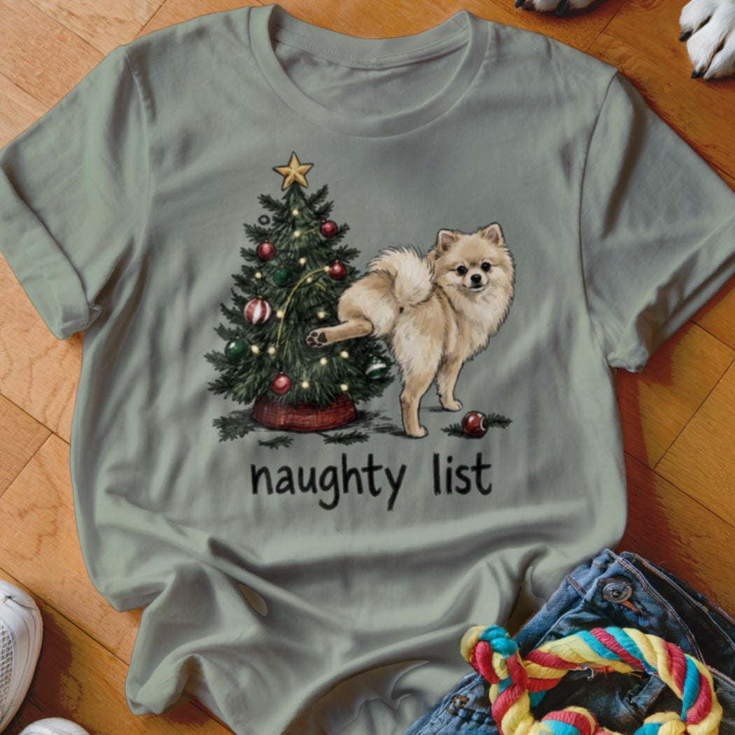Pomeranian dog by a Christmas tree with "naughty list" text.