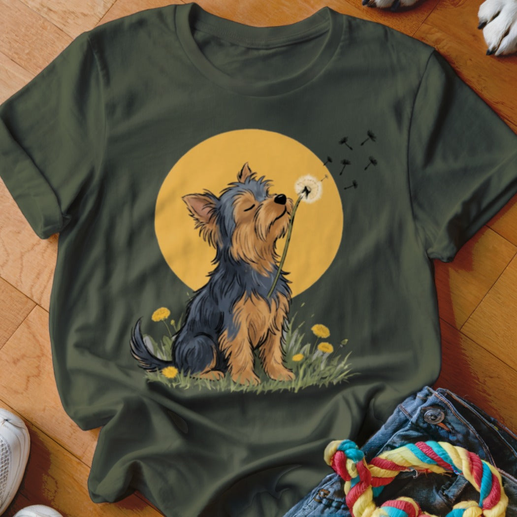 Dark green t-shirt featuring a cartoon Yorkshire terrier blowing dandelion seeds against a yellow sun.