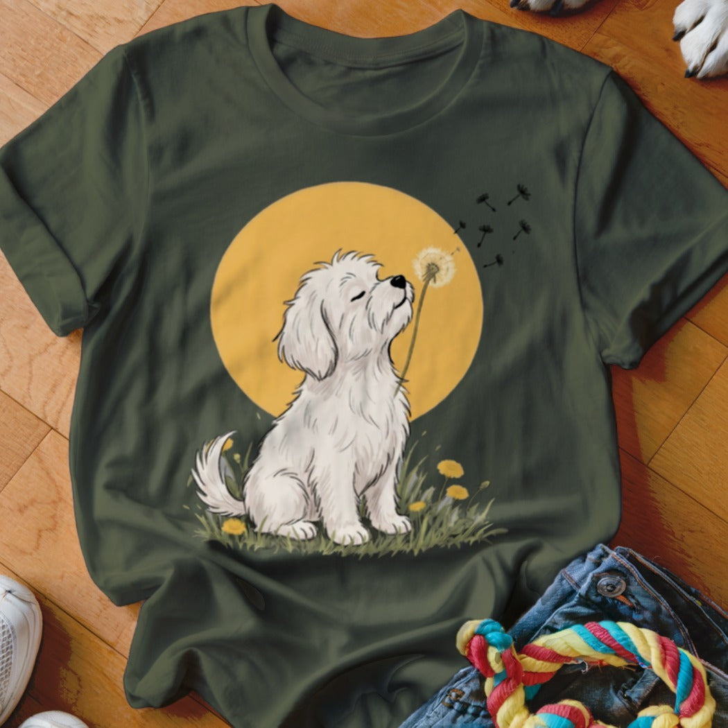 A dark green t-shirt featuring a graphic of a white fluffy dog blowing a dandelion.