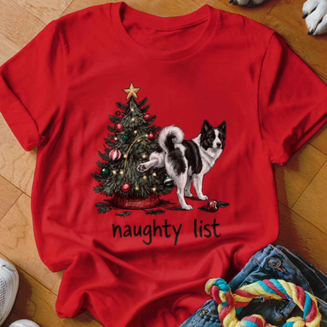Bright red crewneck t-shirt featuring a graphic of a dog lifting its leg on a Christmas tree, with the text naughty list underneath.
