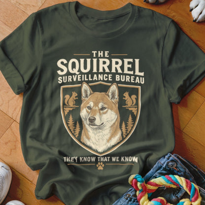 Olive green t-shirt featuring a Shiba Inu graphic and the text "The Squirrel Surveillance Bureau".