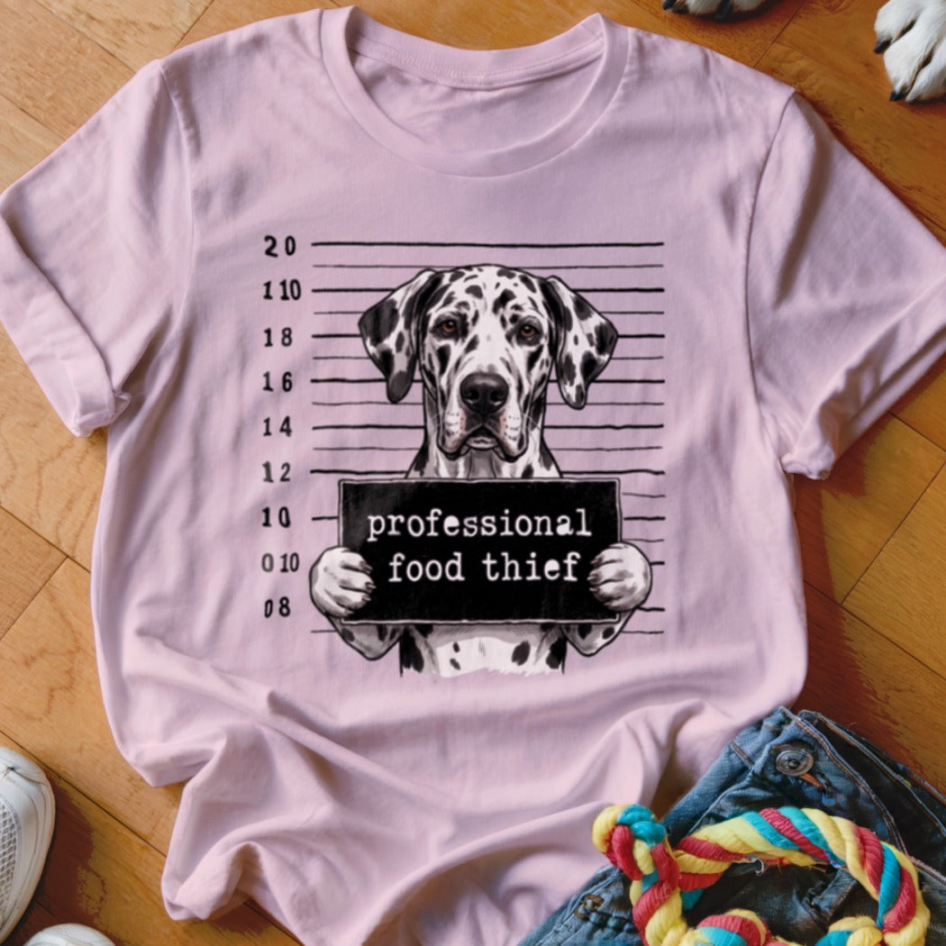 Dalmatian dog in mugshot holding a sign that reads "professional food thief".
