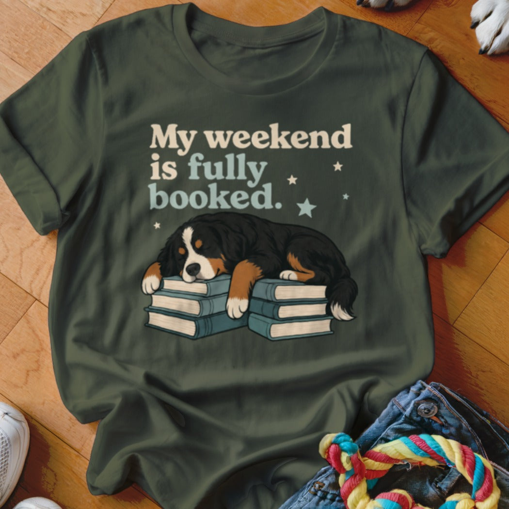 Bernese Mountain Dog sleeping on books with "My weekend is fully booked" text.