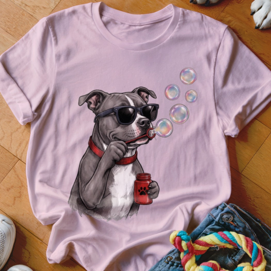 A light pink t-shirt features a graphic of a pit bull wearing sunglasses and blowing soap bubbles.