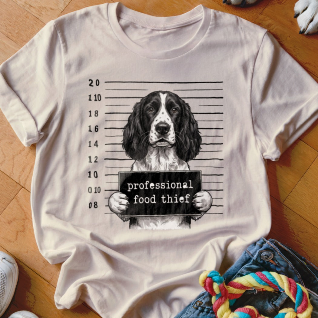 English Springer Spaniel mugshot with "professional food thief" sign.