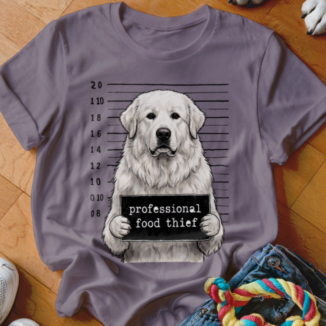 White dog mugshot with "professional food thief" sign on gray t-shirt.
