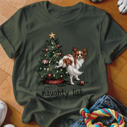 Papillon dog by Christmas tree with ornaments and lights, "naughty list" text.