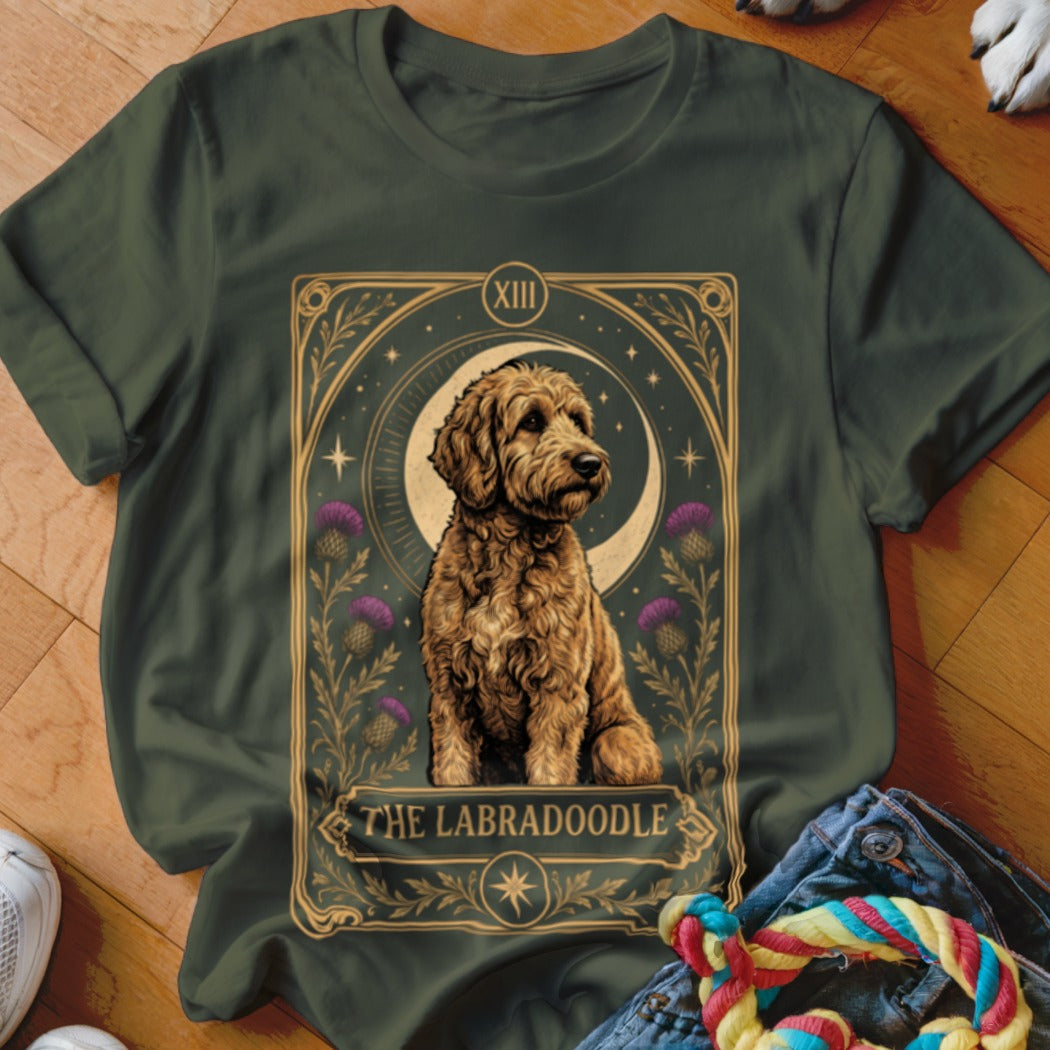 Dark green t-shirt featuring a tarot card graphic of a Labradoodle, moon, stars, and thistles.