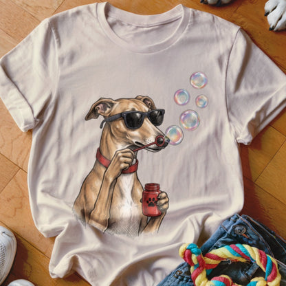 A cream-colored t-shirt features a graphic of a whippet wearing sunglasses and blowing bubbles.