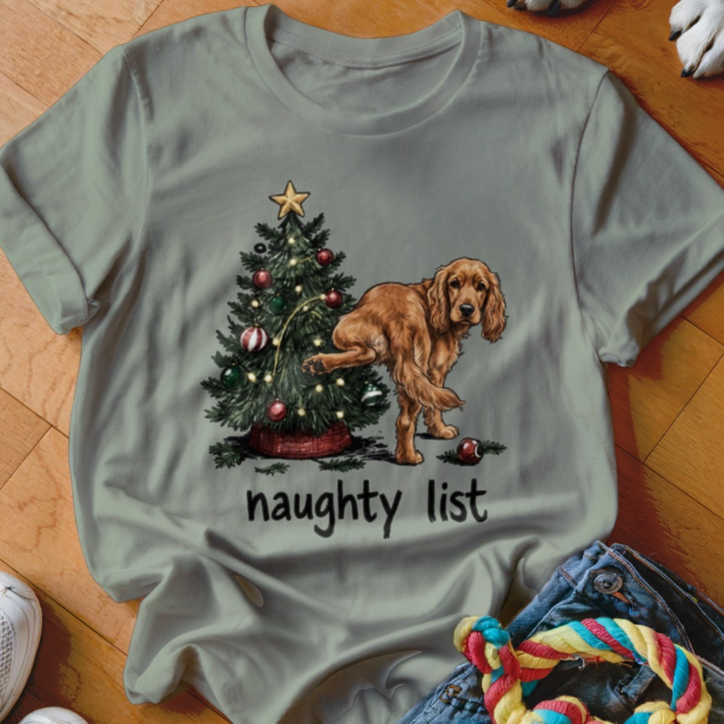 T-shirt graphic of a dog next to a Christmas tree with the words "naughty list".