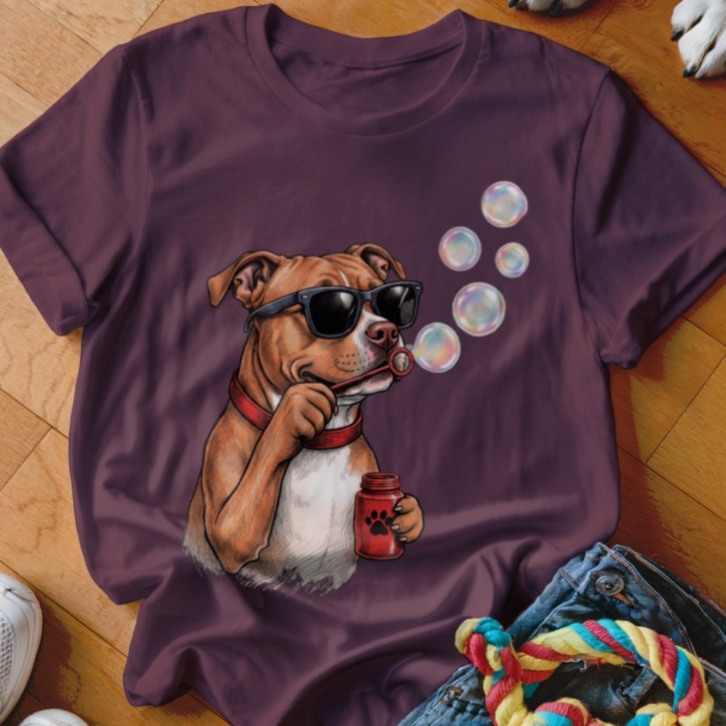 Maroon t-shirt featuring a graphic of a brown dog in sunglasses blowing soap bubbles.