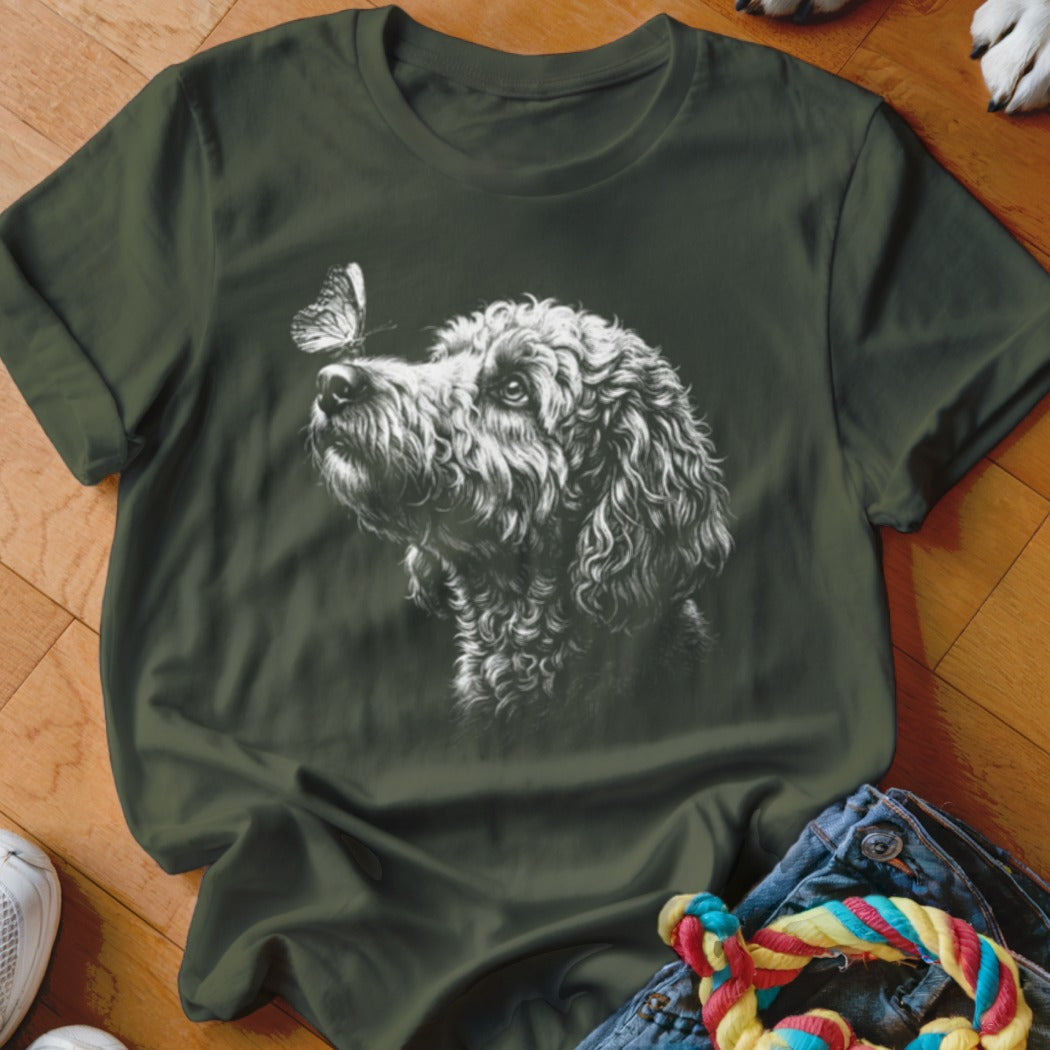 Dark green t-shirt featuring a white sketch graphic of a curly-haired dog looking at a butterfly.