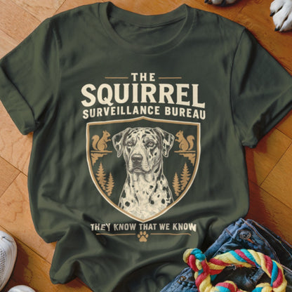 Dark green t-shirt featuring a Dalmatian graphic inside a crest with squirrels and text reading The Squirrel Surveillance Bureau.
