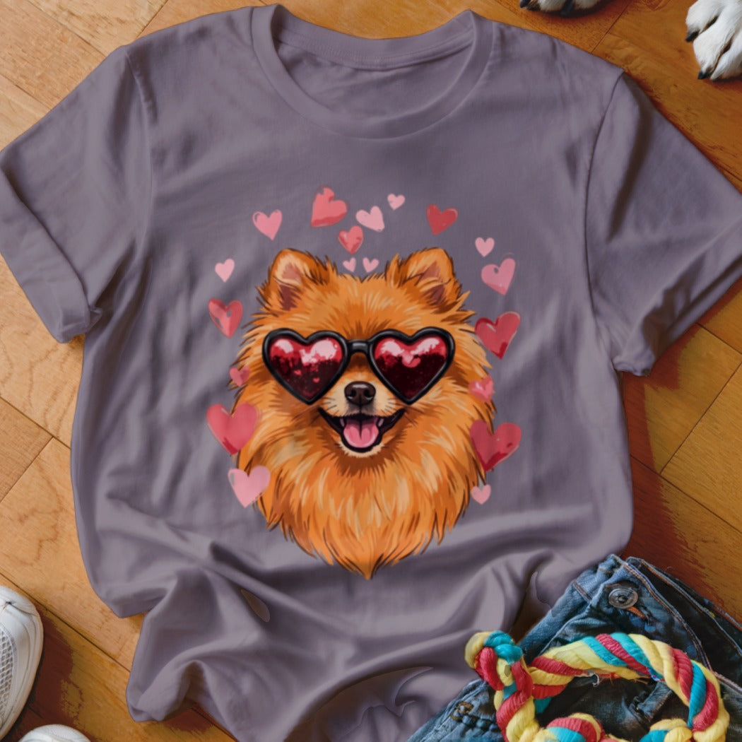 A purple crewneck t-shirt featuring an illustration of a Pomeranian wearing heart-shaped sunglasses surrounded by floating pink hearts.
