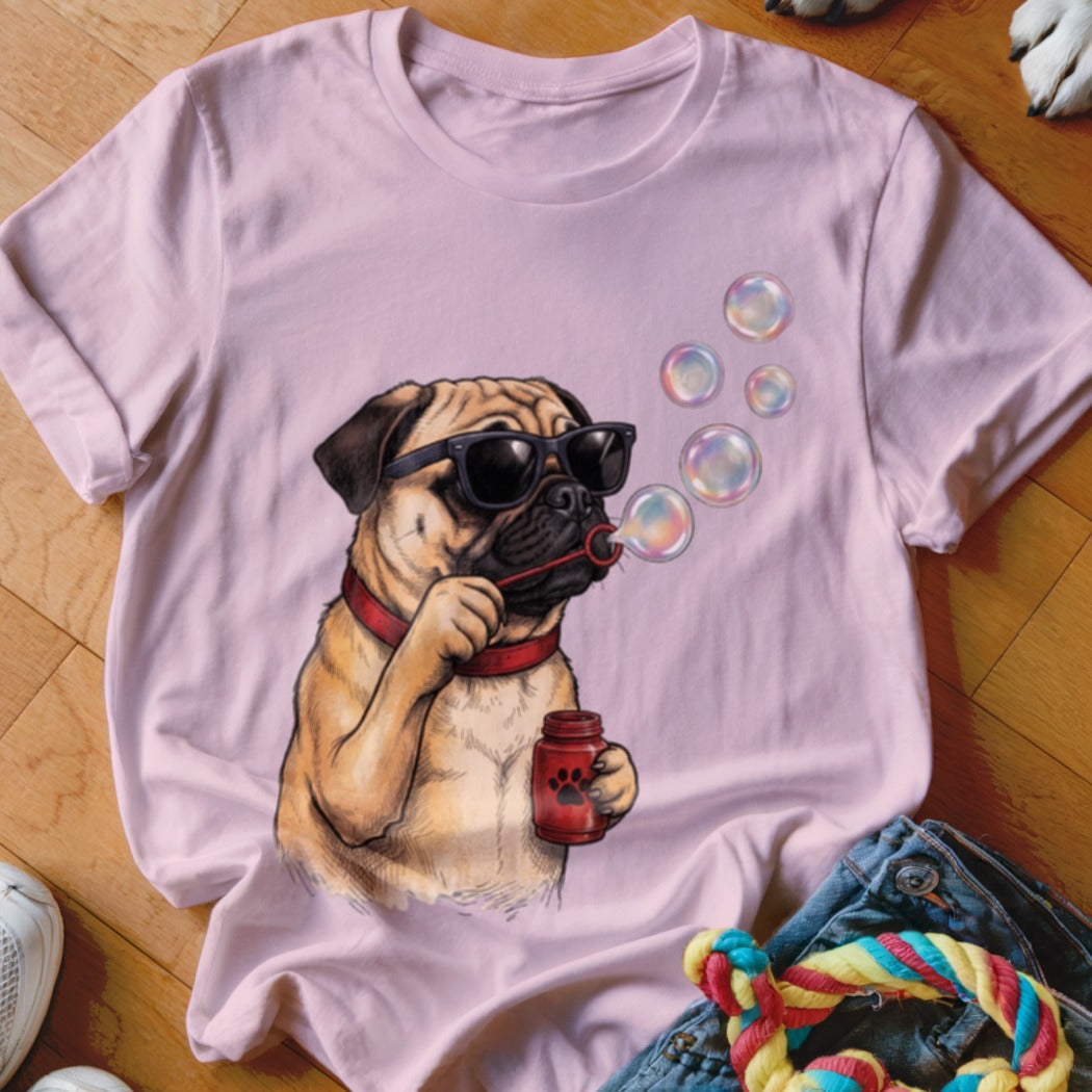 Light pink t-shirt featuring an illustration of a pug wearing sunglasses and blowing soap bubbles.