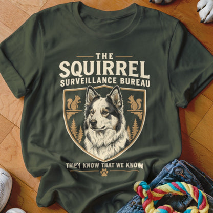 Dark green t-shirt with a graphic of a dog, squirrels, and text reading The Squirrel Surveillance Bureau.