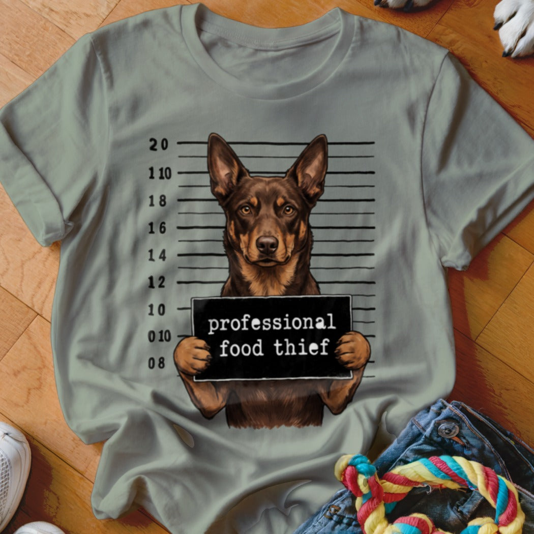 Dog mugshot with sign reading "professional food thief" on a t-shirt.
