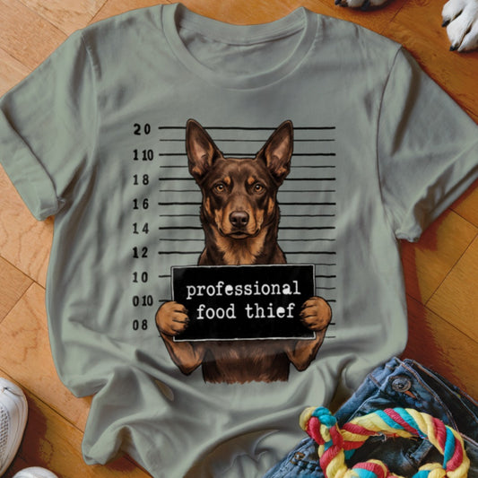 Dog mugshot with sign reading "professional food thief" on a t-shirt.