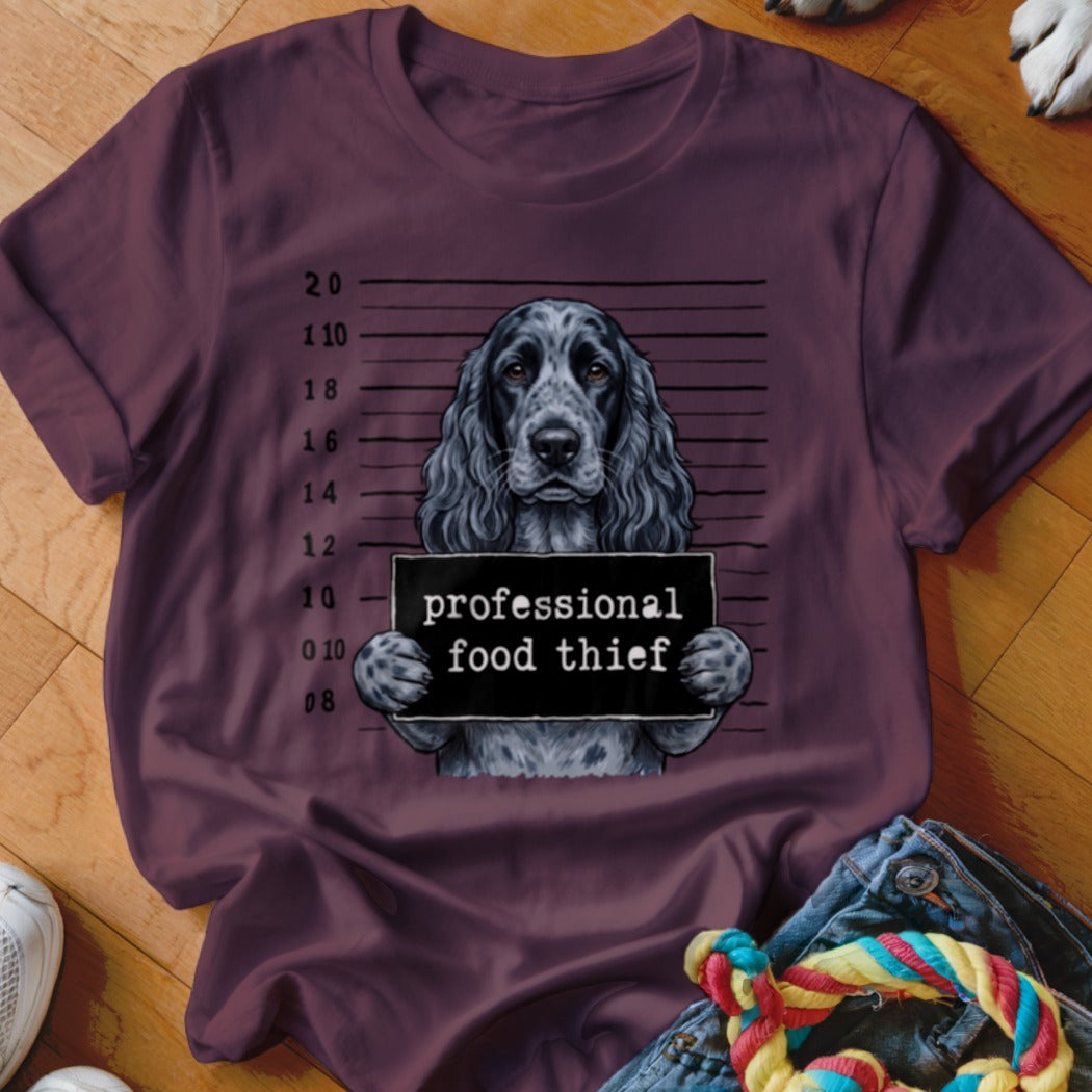 Dog in mugshot with sign "professional food thief"
