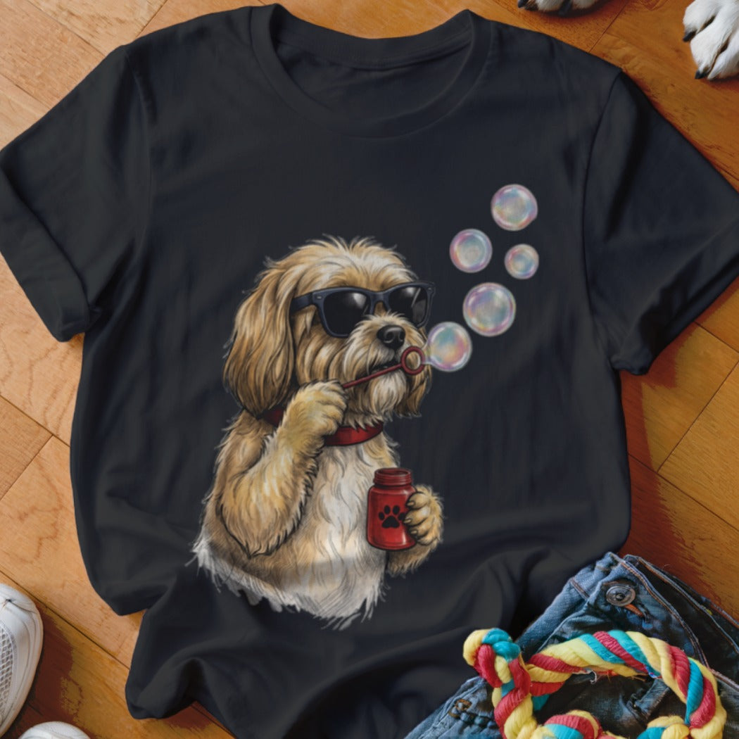 Black t-shirt featuring an illustration of a fluffy blonde dog wearing sunglasses and blowing soap bubbles.