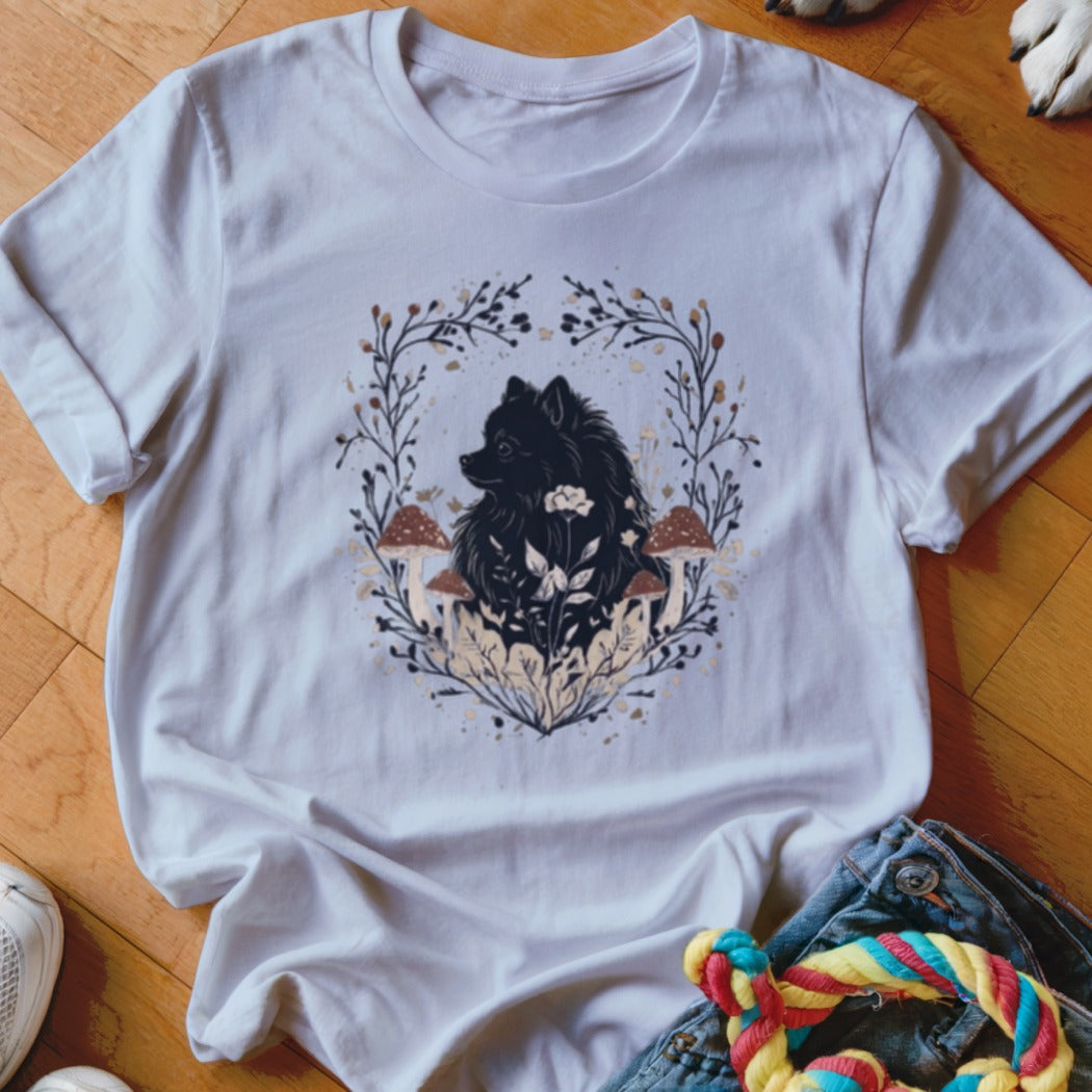 White crewneck t-shirt featuring a graphic of a black dog surrounded by mushrooms, flowers, and branches.