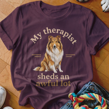 Collie dog graphic with text "My therapist sheds an awful lot" on a maroon t-shirt.