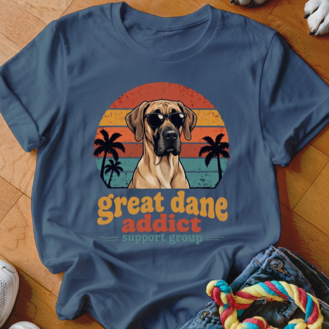 A blue crewneck t-shirt featuring a retro graphic of a Great Dane wearing sunglasses against a sunset.
