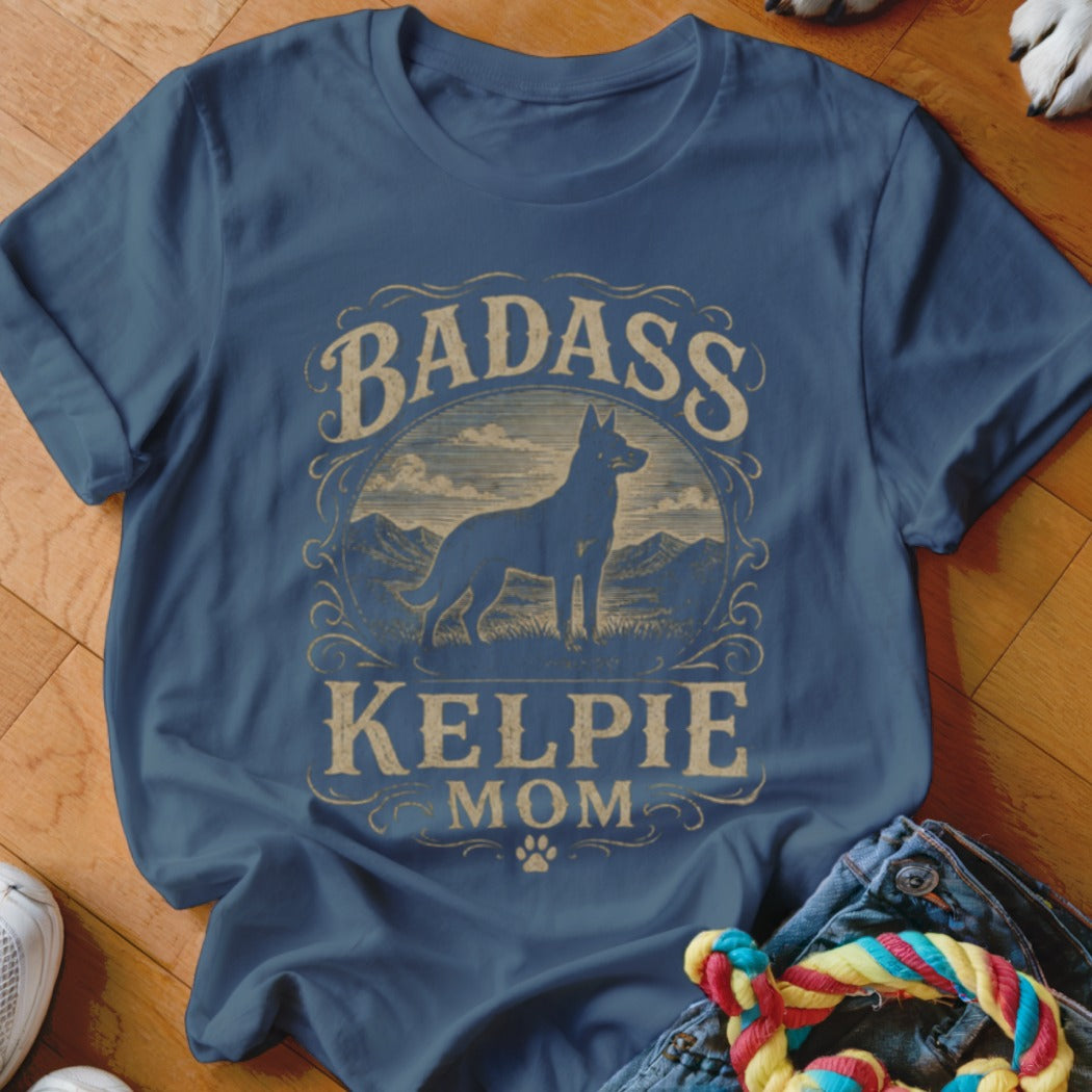 Blue t-shirt with "Badass Kelpie Mom" text and a silhouette of a dog in a landscape.