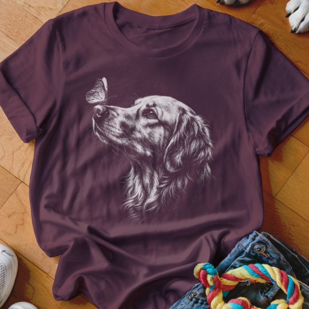 Maroon short-sleeved t-shirt featuring a white line drawing of a golden retriever looking at a butterfly.