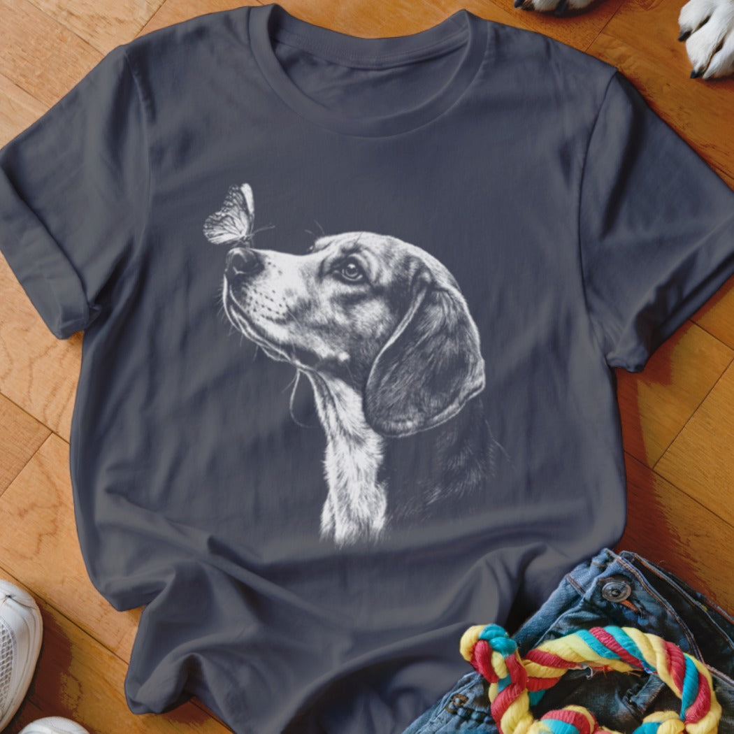 A dark grey crewneck t-shirt featuring a white sketch of a dog looking at a butterfly on its nose.