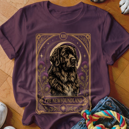 A dark plum t-shirt featuring a tarot-style graphic of a Newfoundland dog and thistle flowers.