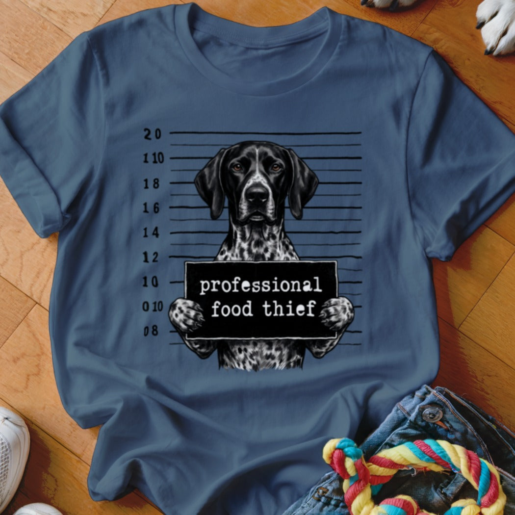 German Shorthaired Pointer in mugshot holding "professional food thief" sign.