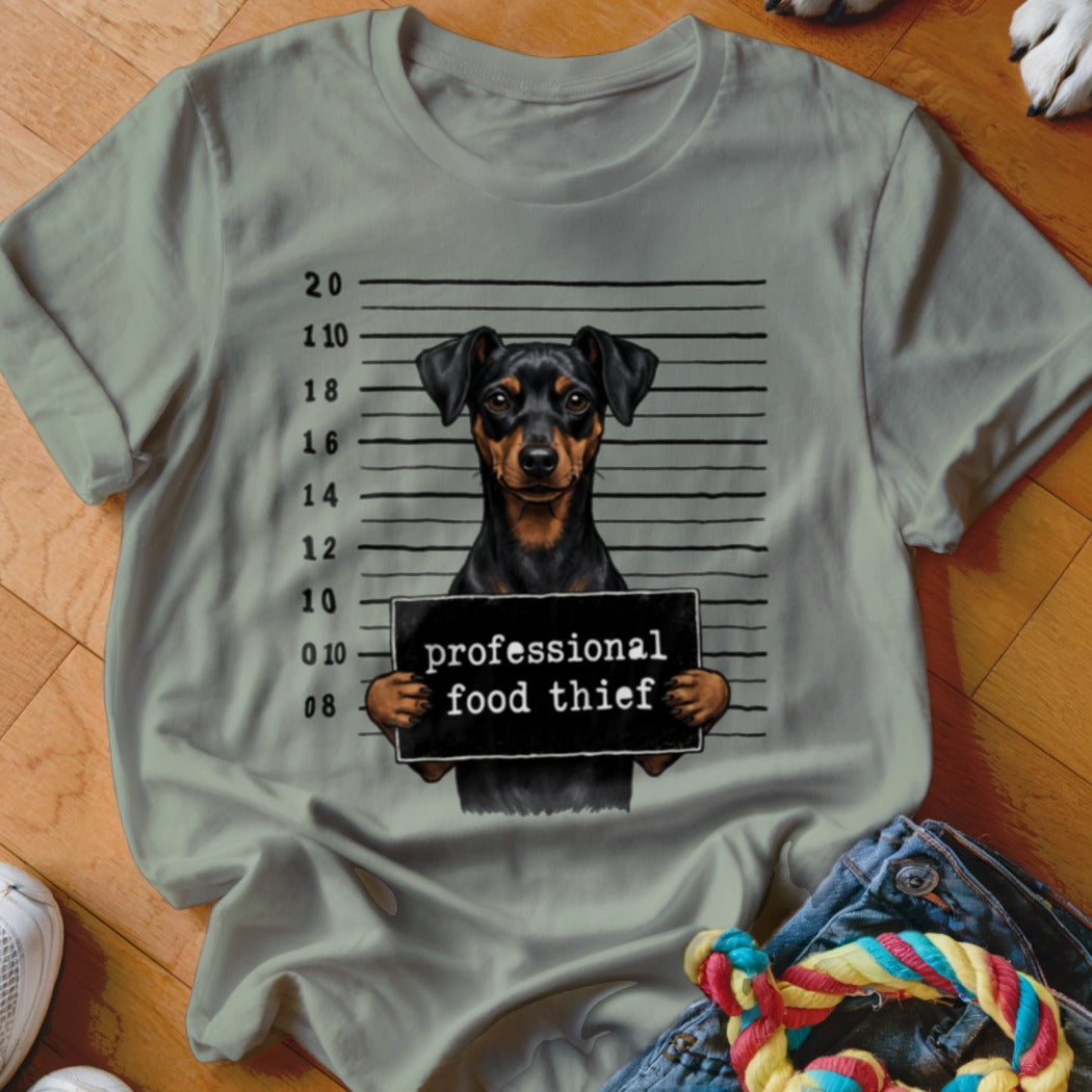 Dog mugshot with sign that reads "professional food thief"