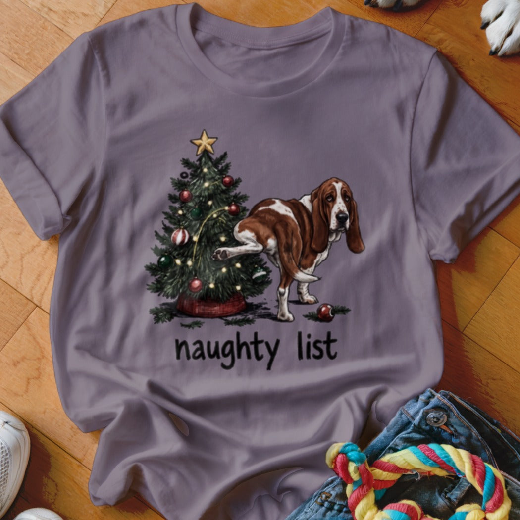Basset hound next to Christmas tree with "naughty list" text.