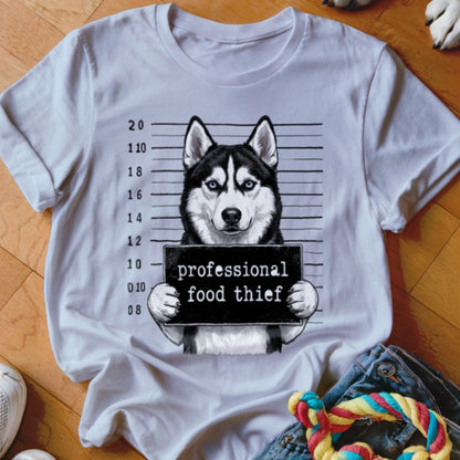 Husky mugshot graphic with text "professional food thief" on a white t-shirt.