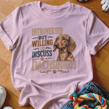 Light pink t-shirt with illustration and text: "Introverted but willing to discuss Dachshunds".